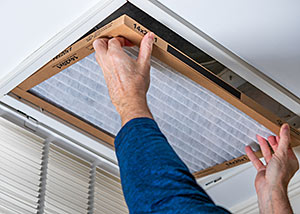 person changing a furnace filter