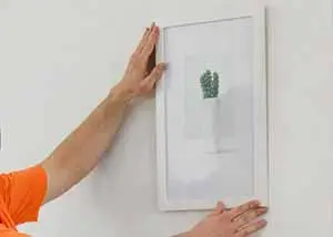 RRG tech hanging a picture on the wall