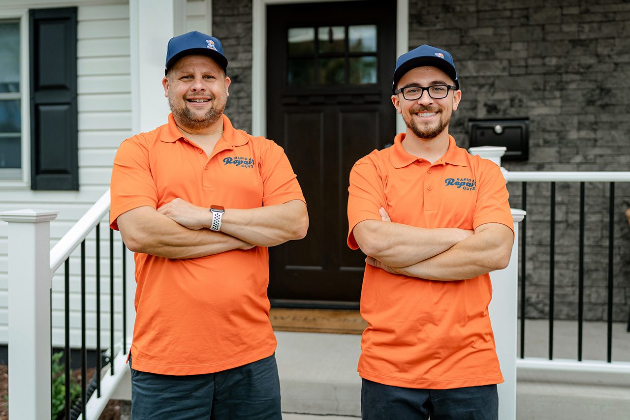 Two Rapid Repair Guys service technicians standing on a job site & smiling